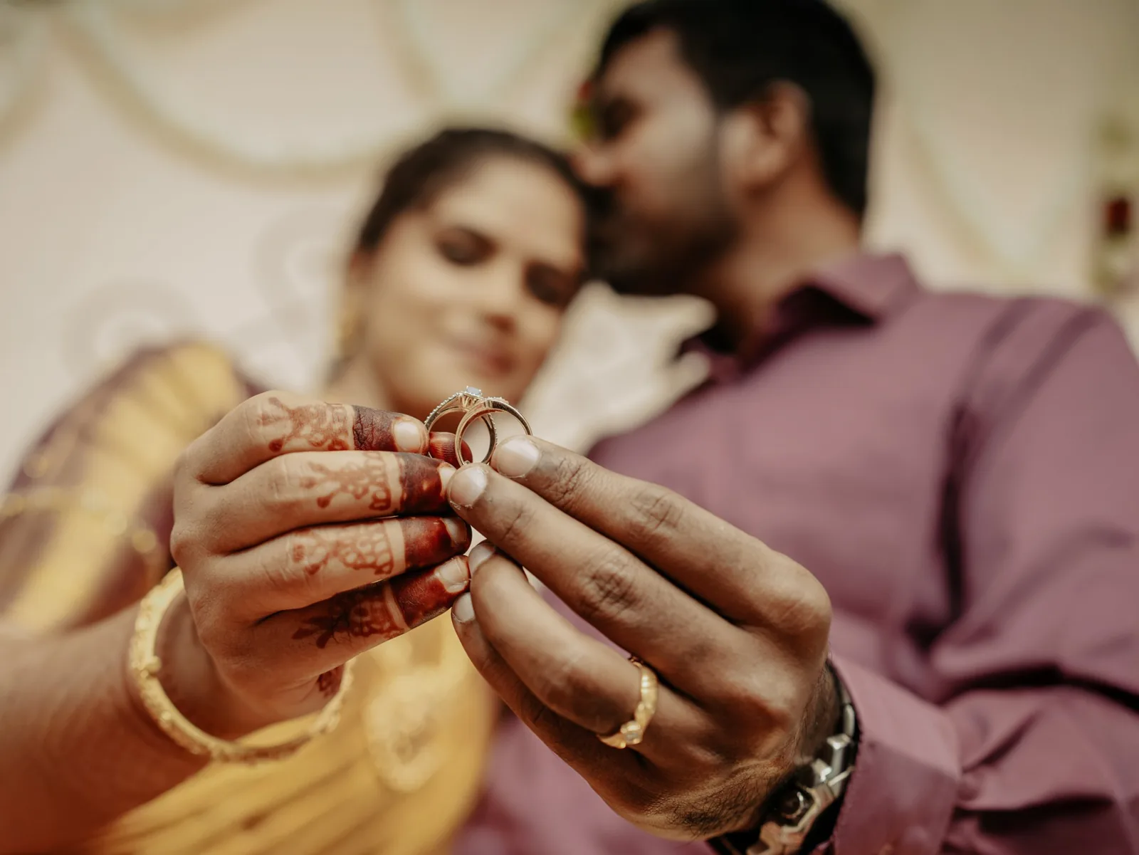The couple holding their rings up to the camera